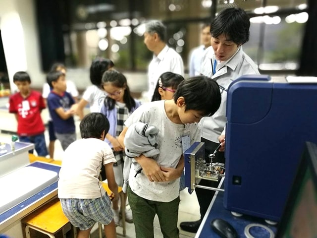 Children looking intently into the microscope