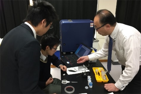 An employee of Hitachi High-Tech explains the electron microscope
