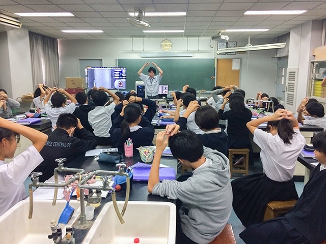 毛髪を触りながら電子顕微鏡で表示された画像を確認する生徒たち