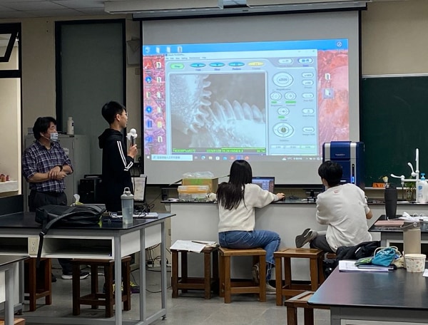 Students using electron microscope images to explain the planthopper larva gear mechanism