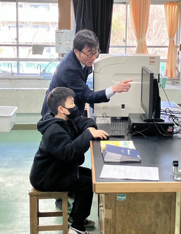 Students operating the tabletop electron microscope