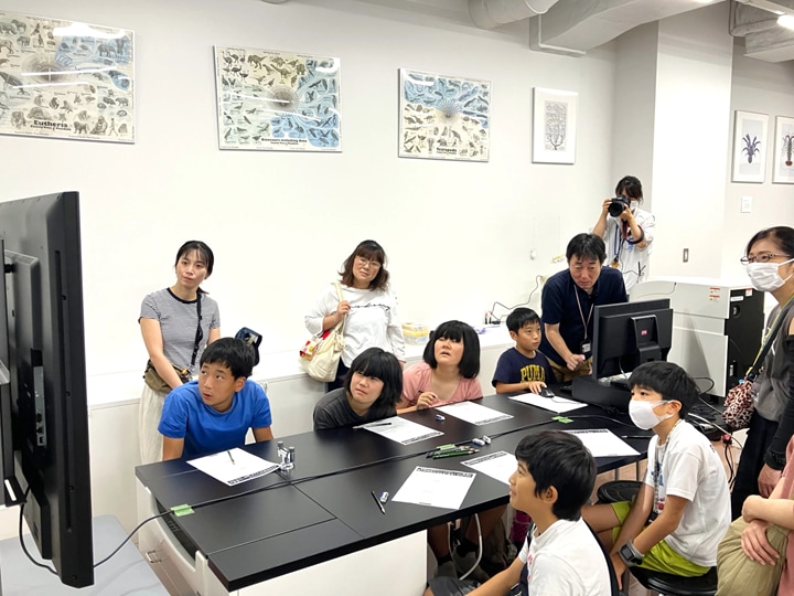 卓上顕微鏡を操作する子どもたち。全員が顕微鏡画像に集中