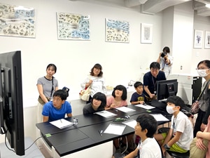 卓上顕微鏡を操作する子どもたち。全員が顕微鏡画像に集中