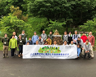 Group photo of local staff members and participants in front of the Insect Hotel